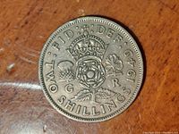 Close-up photo of 1949 UK two shillings coin showing crown, floral emblem, and clear date 1949 with light surface wear.