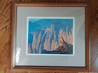 Framed print showing the landscape artwork with visible signature and numbering below the print.