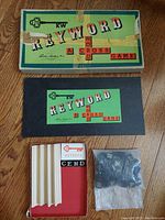 Closed game box and small label/card with game name alongside letter blocks in plastic bag