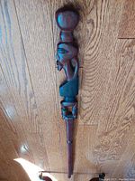 Full view of the carved wooden walking stick showing the rounded top knob and crescent moon carving detail.