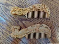 Both combs shown together on wood surface to display overall designs and size.
