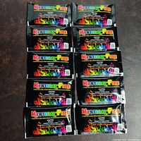 Top view of all 10 unopened Mystical Fire packs arranged in two columns, showing the front packaging with colorful flame graphics and text.