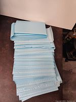 Stack of multiple blue bubble pack envelopes folded flat showing the peel-and-stick flap.