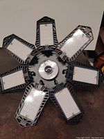 Top view of the LED lamp showing six rectangular LED panels arranged around a circular center.