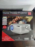 Box front of RCA Home Theater Projector showing product image and main features like Bluetooth, 2 HDMI, HD 720p, rechargeable battery.