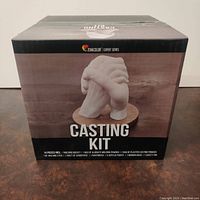 Front view of unopened Zenacolor casting kit box with image of interlocking hands and product name