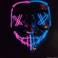 Mask lit up in dark showing neon red and blue LED outlines across eyes and mouth creating a stitched and crossed-eye effect.