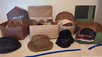 Vintage men's and women's hats displayed with several hat boxes