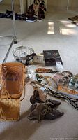 Overview of lot with Longaberger baskets, vintage shoes, costume jewelry, Timex watches, and metal container visible on carpeted floor