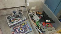 Overall lot in large plastic bin showing Robotix kit box alongside loose parts