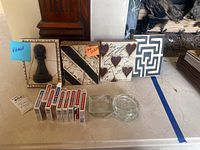 Front overview showing four Sid Dickens wall plaques on countertop with ten playing card decks in front, two clear glass ashtrays on right, striped coasters stacked at far right