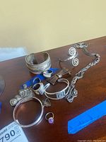 Top view of assorted silver jewelry on wood table