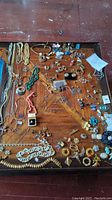 Overview of entire jewelry lot arranged on wooden surface