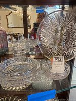 Image showing large cut crystal bowl, ashtray, and candy dish arranged on glass shelf.