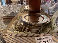 Stack of 12 small silver plate bread plates with polished finish inside a box lined with protective paper.