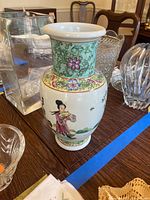 Asian porcelain vase with floral and figure motif on table