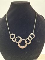 Amos Pewter necklace displayed on black bust showing interconnected open circles design.
