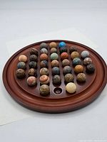 Top-down view showing entire Chinese checkers board with all 41 stone marbles arranged in starting positions.