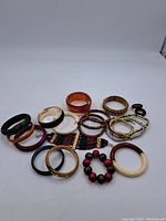 Full view of all bracelets in the lot arranged on a flat surface displaying a variety of colors, materials and styles.