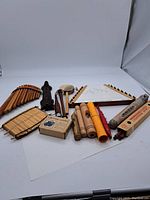 Full view of assorted handheld musical instruments arranged on white backdrop