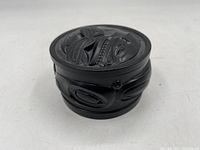 Front angled view of the black resin trinket dish showing carved animal designs on the side and lid.