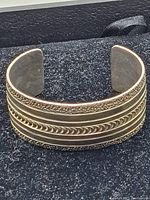 Close-up front view of the sterling silver bangle bracelet showing intricate patterns and textures.