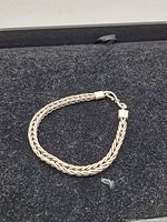 Full view of the silver rope chain bracelet showing length and clasp design on a black background.