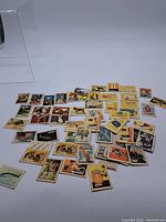 Wide view of approximately 40 vintage Kellogg's collector cards laid out on a white surface showing the variety of subjects including animals, people, and objects.