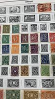 Close up of vintage German stamps showing multiple denominations and colors arranged in rows.