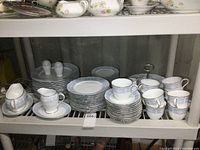 Overall set on shelving showing stacks of plates, cups, saucers, creamer, gravy boat