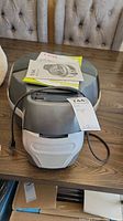 Front image of T-fal Actifry air fryer with manuals on top and power cord visible.