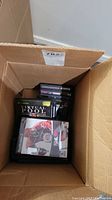 Box containing several video game cases showing NHL 07 for PS2 and Virtual Pool for Xbox