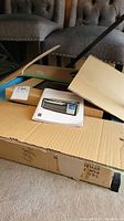 Opened cardboard boxes showing the packaging of the convection oven with user manual on top.