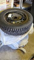 Stack of four winter tires on black steel rims showing tread and rim condition