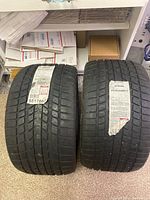 Photo showing the two new Sumitomo tires standing upright side by side with labels visible.