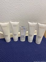 Front view of 5 sealed Joan Rivers Right To Bare Legs lotion tubes showing brand and product name on soft cream color packaging.