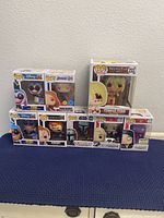 Photo showing all 8 Funko Pop! figures in original boxes displayed on a flat surface including Disney, Marvel, Animation, Star Wars, WWE, and Movies series.