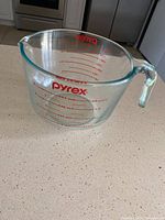 Full view of the Pyrex measuring cup showing shape, handle, and spout on kitchen counter.