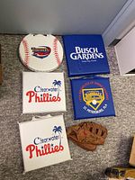 Overview of six seat cushions and one baseball glove arranged on floor