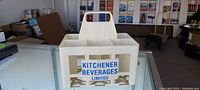 Side view of the white plastic drink carrier with Kitchener Beverages Limited logo.