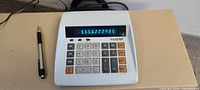 Top view of the vintage electric calculator showing keypad, power cord, and digital numeric display with numbers on screen