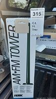 Photo of the Terk Technologies AM/FM Tower antenna in its original box on a truck bed, labeled with lot tag.