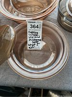 Photo showing part of the set of five clear amber glass CorningWare Vision bowls stacked, with visible ribbed pattern and label indicating CorningWare Vision microwave safe set of 5