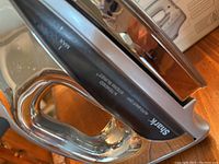 Close up side view of Shark Autostat X Titanium Steam Iron showing handle, control dial, and reflective soleplate
