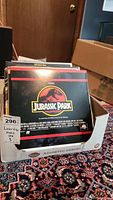 Box of assorted LaserDisc movies showing Jurassic Park cover prominently