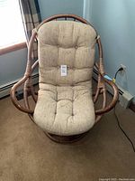 Front view of Bali bamboo egg chair with cream/beige cushioned seat, showing overall structure and wear.