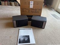 Pair of Bose Model 141 speakers displayed with original box and user manual.