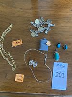 14k gold chain, ring labeled 10k?, charm bracelet, bow pendant, snake chain, turquoise earrings and pendant, silhouette pendant on foam
