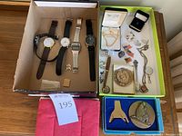 Overview of watches, jewelry, coins, pins, spoons, chains, cuff links, and pen in boxes