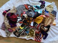 Overall image of large pile of assorted scarves with different colors and materials showing size and variety